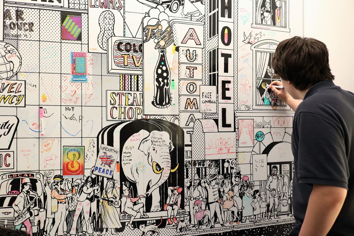 photograph of a person in a grey shirt drawing on a dry erase board