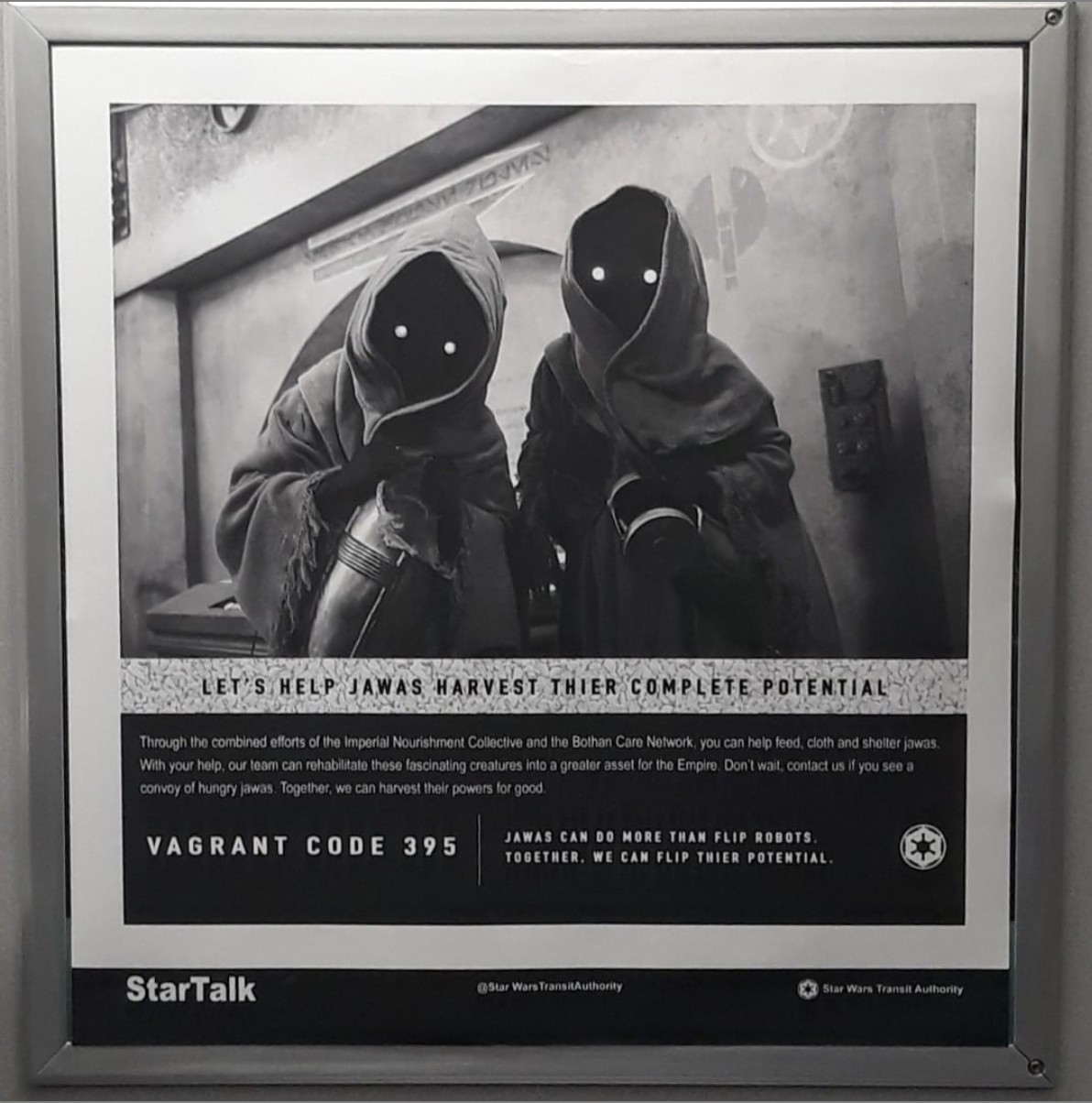 poster inside of an MTA subway cart of two creatures wearing capes from the Star Wars films