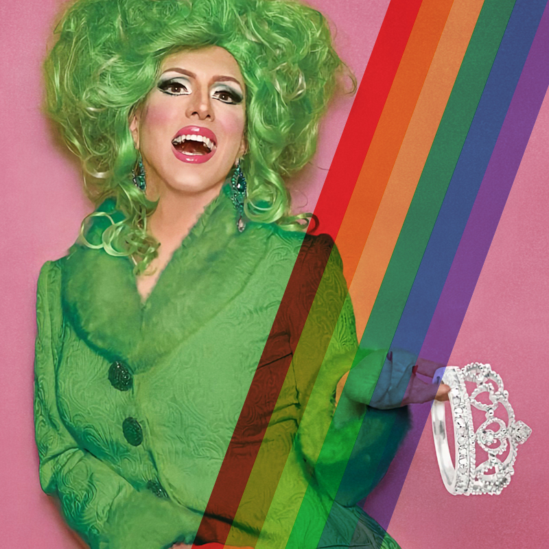 photograph for a Birthday Drag Brunch event of person dressed in green drag holds up a tiara and smiles open-mouthed at the camera