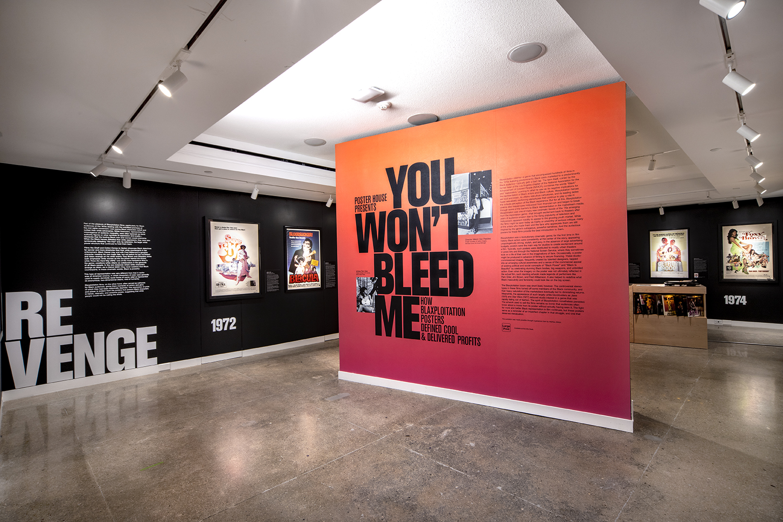 Blaxploitation gallery displaying two black anchor walls lined with posters and a freestanding red wall inlaid with photos.