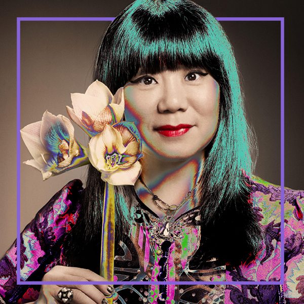 Photo of Anna Sui holding flowers with a developing negative effect throughout