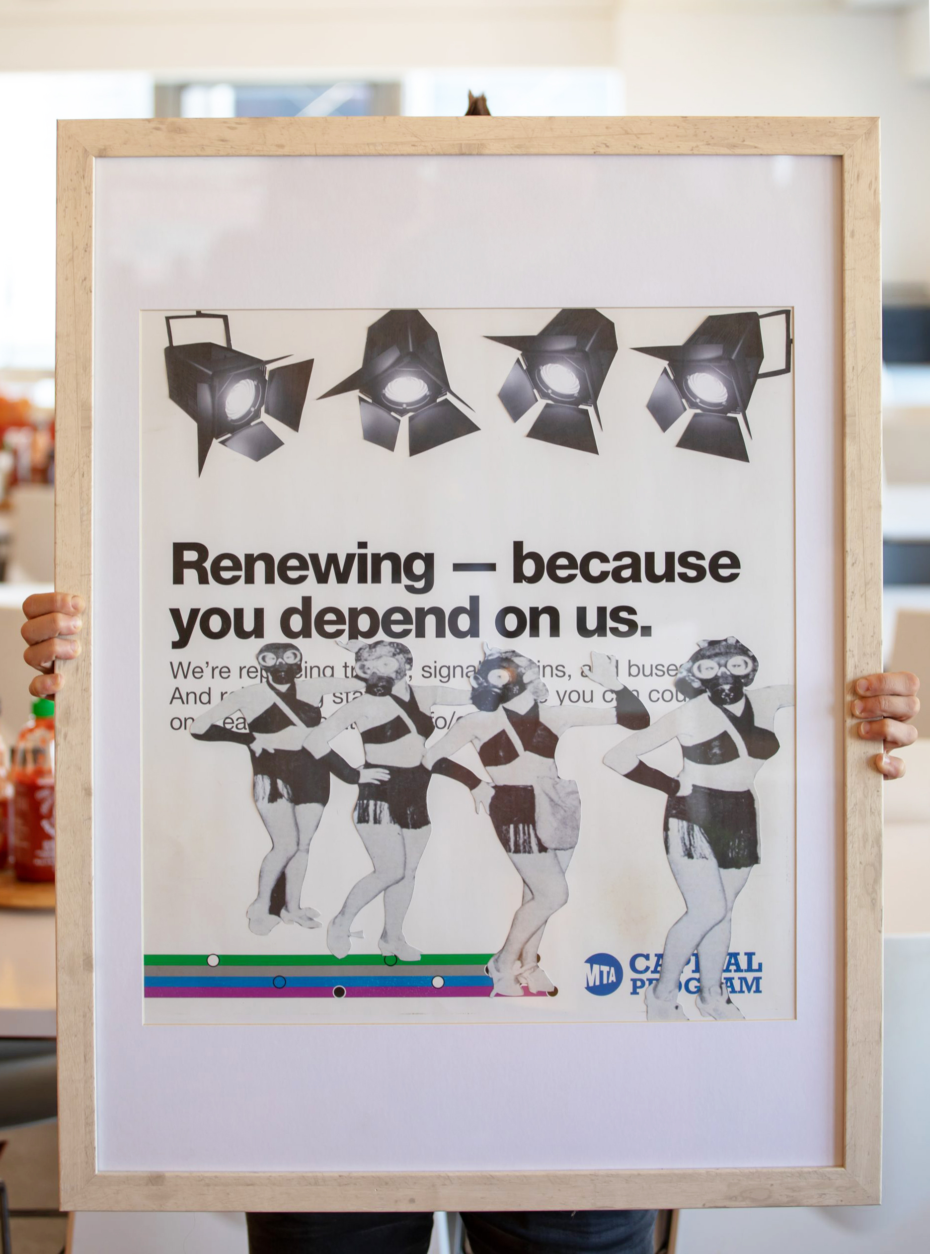 Photograph of a framed work of art featuring black and white images of dancers on top of an MTA announcement poster.