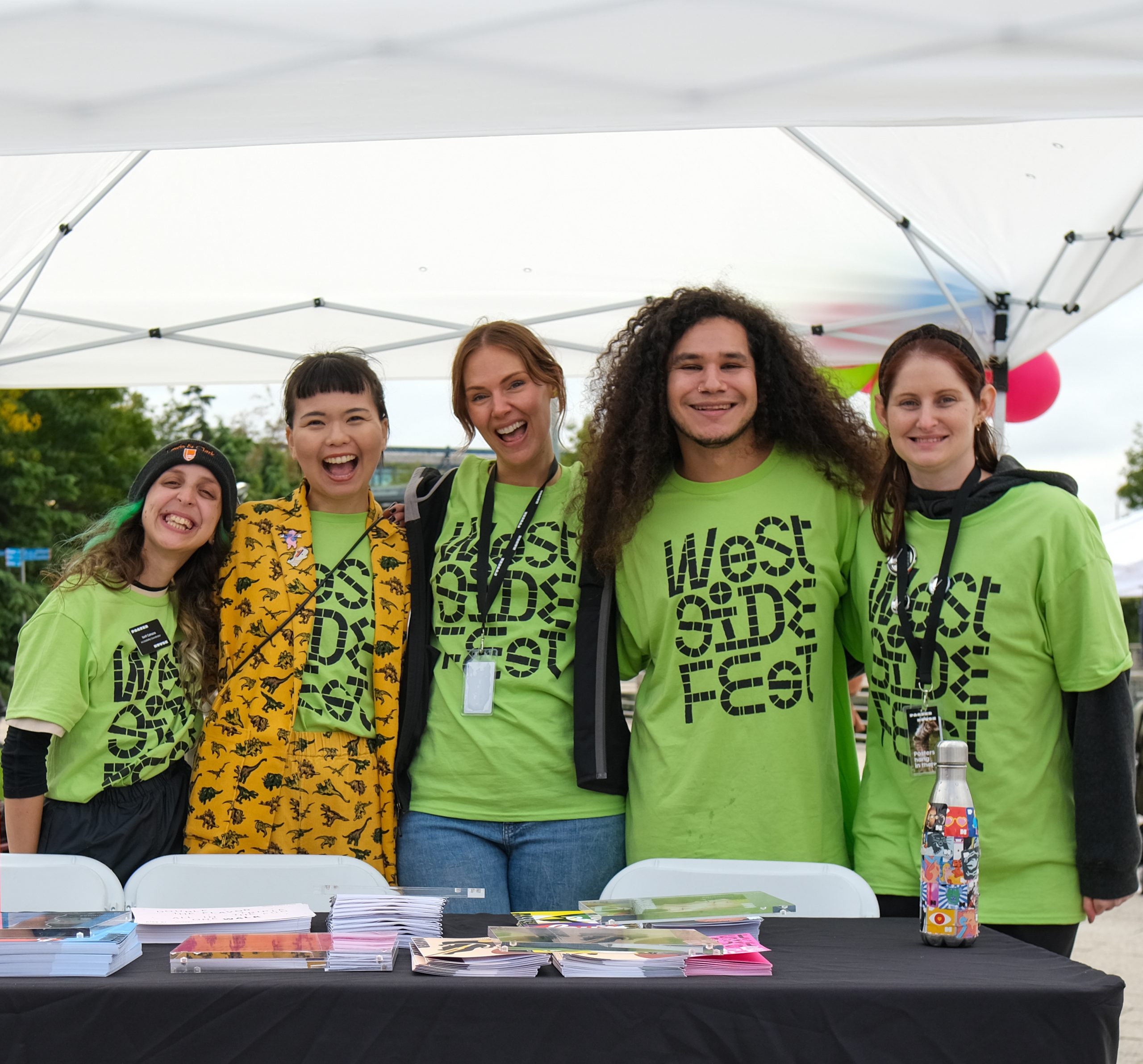 A group of people stand behind a table