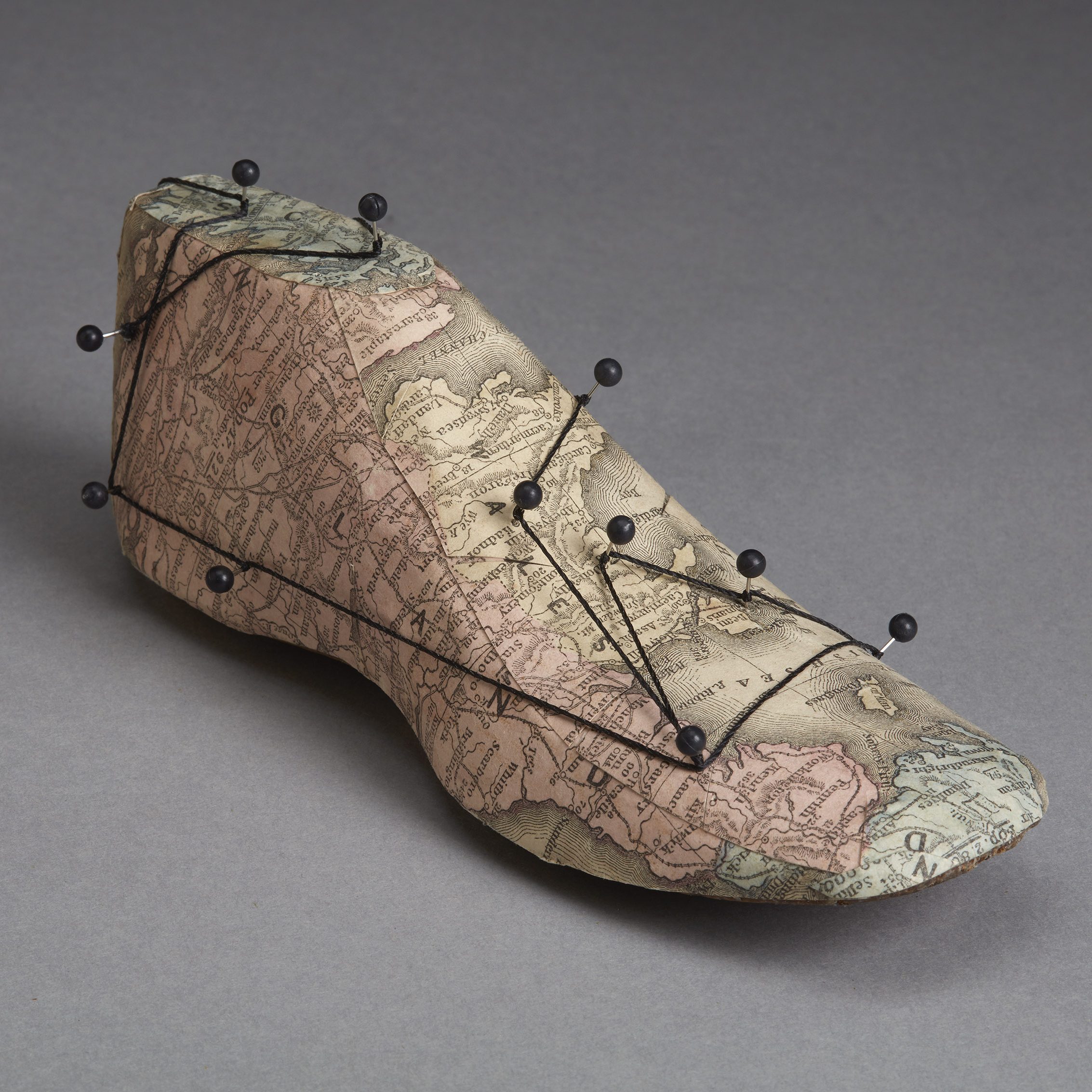 A tuffed foot with pins and strings in an art gallery