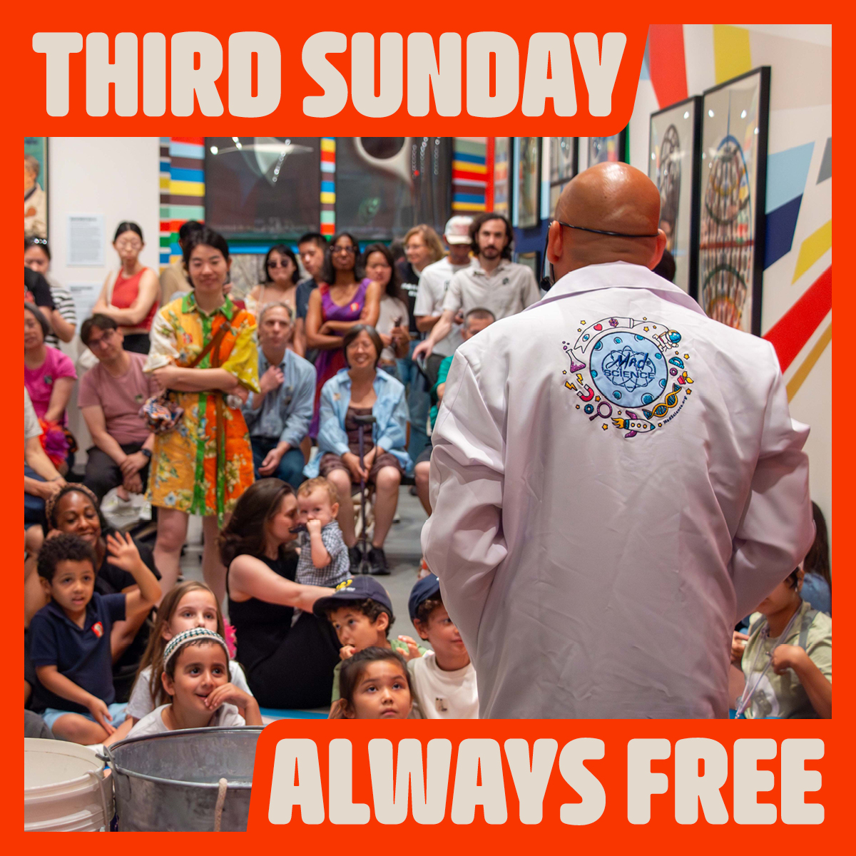 Digital image of a man wearing a lab coat standing looking out over an audience of children and their parents.