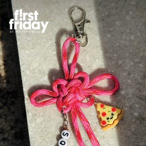 A pink keychain made out of knotted rope and various charms.
