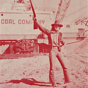 A man in holding up a shotgun in one hand.