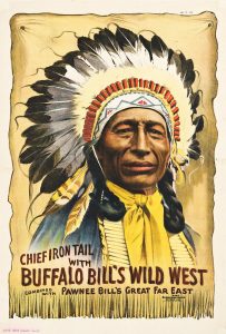 A vintage poster shows an illustration of a Native American man with black braids and a feather headdress. This is Chief Iron Tail, a member of Buffalo Bill's Wild West show.